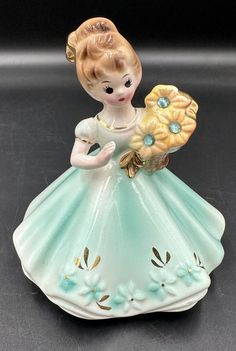 Celebrate a special girl's birthday with this vintage Josef Originals figurine. The small porcelain figurine features a charming sunflower pattern and is adorned with an aquamarine birthstone. Measuring 4 inches in length and height, this original piece from the 1950s is a lovely addition to any collection. The figurine is part of the Growing Up Girls collection and is perfect for anyone who loves vintage collectibles. It is not customized and is an original piece from Japan. This figurine is a must-have for anyone who loves porcelain and wants to add a touch of nostalgia to their decor. No chips or cracks. Excellent condition! Josef Originals Figurines, Aquamarine Birthstone, Josef Originals, Growing Up Girl, March Birthday, Porcelain Figurine, Sunflower Pattern, Girls Collection, Special Girl