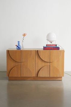 a sideboard with books and a lamp on top