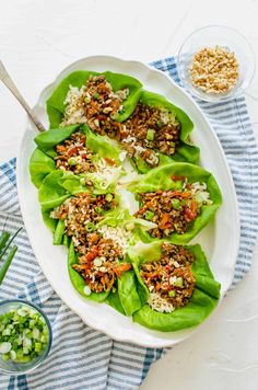 lettuce wraps filled with meat and vegetables on top of a blue and white towel