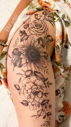 a woman's thigh with sunflowers and roses on it