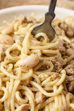 pasta with meat and sauce in a white bowl on a wooden table, ready to be eaten