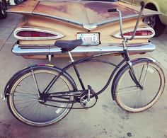 an old bicycle is parked in front of a car