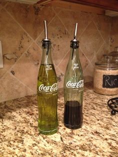 two empty coke bottles sitting on top of a kitchen counter next to a spice jar