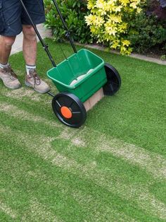 a man is cleaning the grass with a push mop