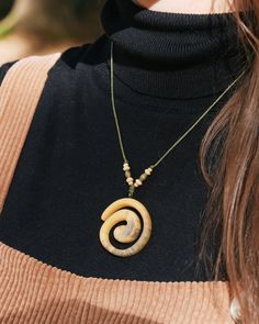 a woman wearing a necklace with an animal's head on it