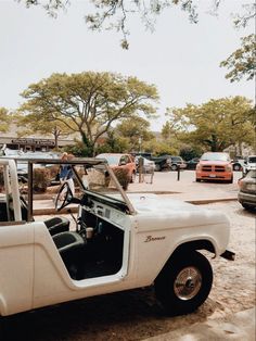 an old white pickup truck parked in a parking lot