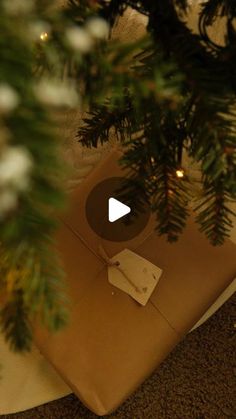 a present wrapped in brown paper under a christmas tree