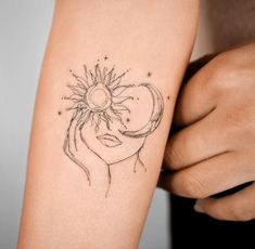 a woman's arm with a sun and moon tattoo on it