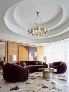 a living room with two couches and a chandelier hanging from the ceiling