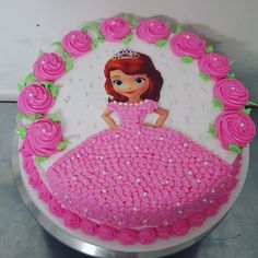 a birthday cake decorated with pink frosting and princess figure on it's side