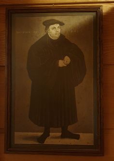 an old photo of a man in a black coat and hat with his hands on his hips