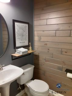 a white toilet sitting next to a sink in a bathroom under a framed map on the wall