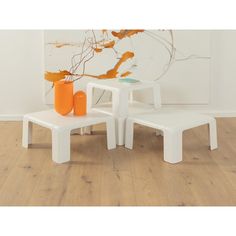 a white table with two orange vases on it