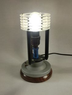 a lamp that is sitting on top of a wooden base with a light bulb attached to it