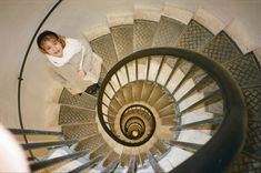 a woman standing on top of a spiral staircase