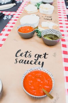 several bowls of soup on a table with a sign that says let's get saucey