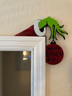 a sign that says merry grinch mash on the side of a wall next to a mirror