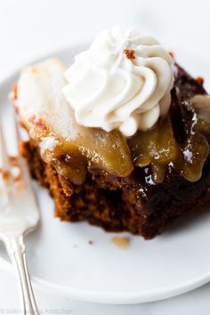 a piece of cake on a white plate with whipped cream and caramel toppings