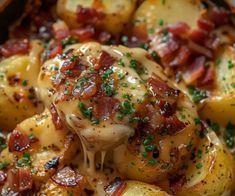 a close up of potatoes with bacon and cheese in a skillet on a table