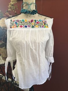 Gorgeous hand embroidered Mexican blouse is comfortable, fresh and stylish With beautiful San Antonio flower embroidery detailed work on the top The fabric is cotton, fresh, gauzy and slightly see through, 3/4 sleeve Get the Boho style you like Perfect to wear with your favorite jeans Perfect for summer season! You will love your unique one of a kind piece Is a MUST HAVE in you wardrobe Every blouse is individually handcrafted Color may vary on stitching as each blouse is unique Perfect for any Spring Floral Embroidered Top With 3/4 Sleeve, Floral Embroidered Top With 3/4 Sleeves For Spring, Folk Style Blouse With Tonal Embroidery For Spring, Summer Bohemian Blouse With Tonal Embroidery, White Cotton Peasant Top With Embroidered Sleeves, White Cotton Blouse With Tonal Embroidery, Cotton Embroidered Top With 3/4 Sleeves, Summer Cotton Peasant Top With Intricate Embroidery, Bohemian Cotton Blouse With Tonal Embroidery