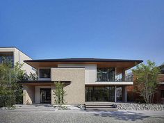 a modern house with an outdoor patio and stone walkway