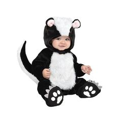 a baby in a skunko costume sitting on the ground with its paws out