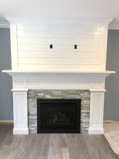 an empty living room with a fireplace and white painted brick surround the fire place in the center