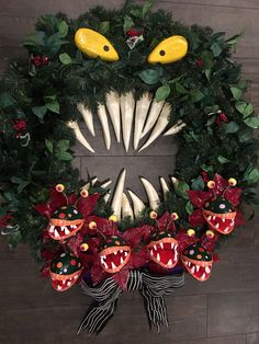 a wreath decorated with fake teeth and red flowers