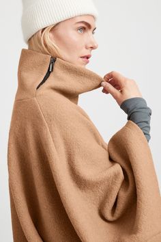 A stylish wool winter cloak, our Avery Cape is the ideal choice for heading out into the cold. Fashioned from Italian virgin wool and offered in fresh neutrals that pair well with any combination of clothing, this women’s wool cape is designed with a loose silhouette. Simple. Elegant. Cozy. Layer her over anything for an instant ready-to-go look. Avery's high collar has a side zipper for style and easy wear. This wool winter cape is lined for added warmth and comfort. | Maritza Fall Merino Wool Outerwear, Cozy Merino Wool Outerwear For Cold Weather, Modern Merino Wool Outerwear For Fall, Fall Merino Wool Outerwear With Funnel Neck, Beige Cape For Winter Workwear, Chic Cashmere Cape For Winter, Oversized Merino Wool Outerwear For Winter, Versatile Funnel Neck Fall Outerwear, Versatile Funnel Neck Outerwear For Fall