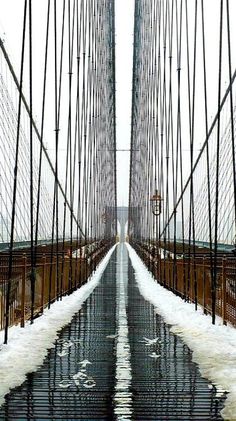 a long bridge that has snow on the ground