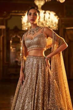 This antique gold lehenga set features intricate embroidered in sequin & crystal work The matching blouse shows tassels at the waist and t is paired with a matching net dupatta with border and tassels on all four sides.From Seema Gujral's Falaknuma collection. DELIVERY TIMEPlease allow 8-12 weeks for your outfit to arrive. FABRIC DETAILSNet Professional cleaning only. Glamorous Traditional Drape Sets With Dupatta, Glamorous Gold Sets With Intricate Embroidery, Glamorous Gold Sharara With Mirror Work, Glamorous Gold Lehenga With Resham Embroidery, Glamorous Festive Choli With Intricate Embroidery, Glamorous Lehenga With Mirror Work And Traditional Drape, Glamorous Anarkali Set With Resham Embroidery, Glamorous Embellished Festive Anarkali Set, Glamorous Traditional Wear With Dupatta