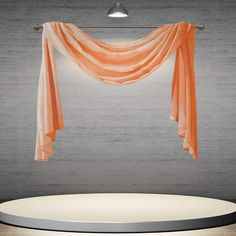 an orange drape hanging over a round table