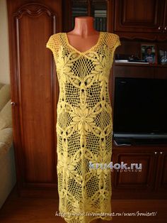 a yellow crocheted dress sitting on top of a wooden floor