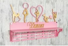 a pink shelf with some gold metal decorations on it and the word mama spelled out