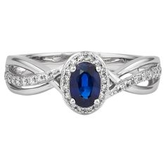 Elevate your elegance with this exquisite ring, crafted in luxurious 18K white gold. At its center, a captivating blue sapphire radiates deep, rich hues, surrounded by a halo of sparkling diamonds that enhance its brilliance. The intricate design showcases fine craftsmanship, with the gemstones set securely to ensure lasting beauty. Perfect for special occasions or as a statement piece in your collection, this ring combines timeless sophistication with modern flair. A true treasure for any jewelry lover. Blue Sapphire Ring in 18Karat White Gold with Diamond. Blue Sapphire: 0.55 carat, 6X4mm size, oval shape. Diamonds: 0.08 carat, 1.00mm size G color, VS clarity. Diamonds: 0.08 carat, 1.20mm size G color, VS clarity. Gold: 3.58g, 18Karat white gold. R929 Blue Sapphire Ring, Sapphire And Diamond Ring, Blue Sapphire Rings, Intricate Design, Sparkle Diamonds, Jewelry Rings Engagement, Showcase Design, Jewelry Lover, Oval Shape