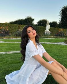 a woman sitting in the grass with her legs crossed