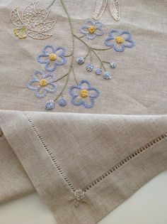 two pieces of linen with embroidered flowers on them