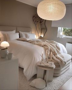 a white bed sitting in a bedroom next to two lamps on either side of it