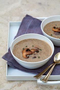 two bowls of mushroom soup on a tray