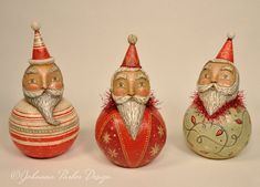 three christmas ornaments with santa hats and beards