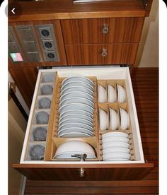 an open drawer with dishes in it