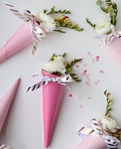 pink paper cones with white flowers and ribbons