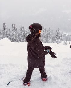 a person standing in the snow with skis on their feet and wearing goggles