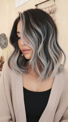 For those who love to embrace bold styles, dynamic silver and gray highlights on black hair are the ultimate choice. The cool-toned highlights create a beautiful contrast against dark hair, giving it a multi-dimensional, luminous finish that stands out in any light. #GrayAndSilverHair #BlackHairInspiration #EdgyHighlights Chunky Gray Highlights On Dark Hair, Black Hair With Milk Tea Highlights, Black Hair With Ash Grey Highlights, Dark Brown With Silver Highlights, Silver Brown Hair Balayage, Short Black Hair With Blonde Highlights, Dark Brown With Ash Highlights, Non Bleach Hair Color For Black Hair, Gray Highlights On Black Hair