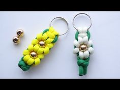 two keychains with flowers on them sitting next to each other, one is yellow and the other is green