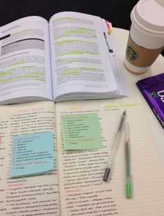 an open book sitting on top of a table next to a cup of coffee