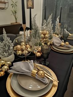 the table is set with gold and silver plates, napkins, and candlesticks