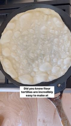 an uncooked tortilla being cooked in a skillet on the stove