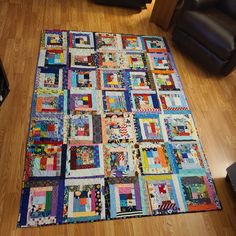 a quilt is laying on the floor next to a chair