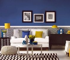 a living room with blue walls and yellow accents on the wall, white couches and black and white checkered rugs